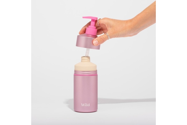Image A hand putting the cap on Wild's refillable body wash.